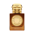 CR Signature Burberry Goddess Amber Vanilla Intense parfymeflaske i ravfarget glass med gullkork mot en mørk bakgrunn.
